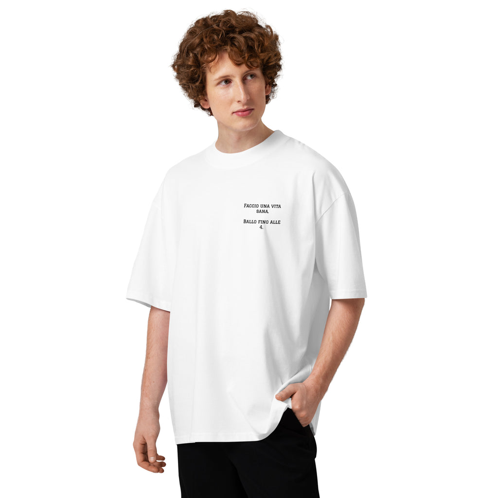 T-shirt oversize unisex bianca con ricamo lato cuore Faccio una vita sana ballo fino alle 4, fit comodo per serate e bachata, brand TLR Social.